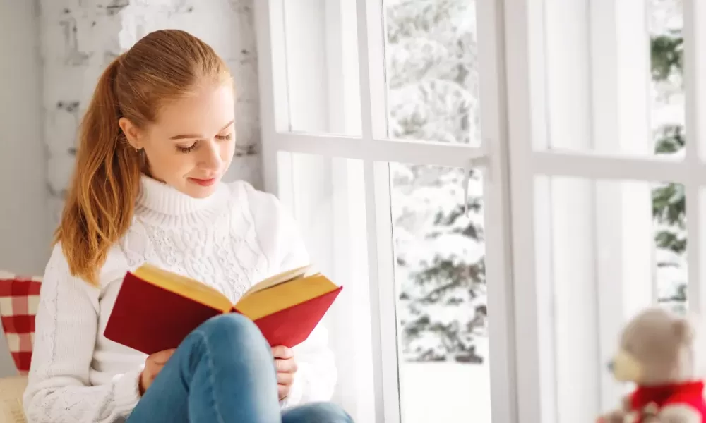 Woman reading inside during winter